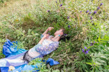 Bir kadın çiçek çayırında dinleniyor, Karpat dağlarında, yaz mevsiminde.
