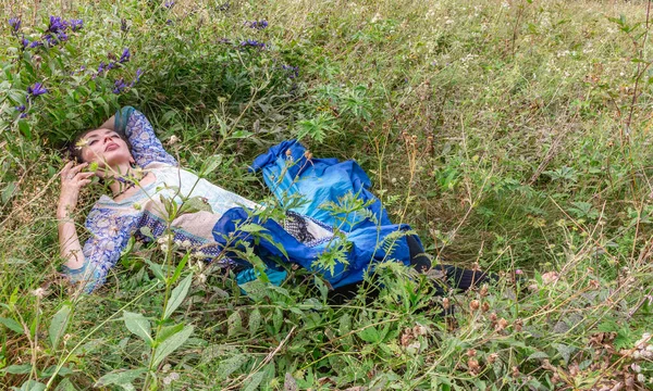 Bir kadın çiçek çayırında dinleniyor, Karpat dağlarında, yaz mevsiminde.
