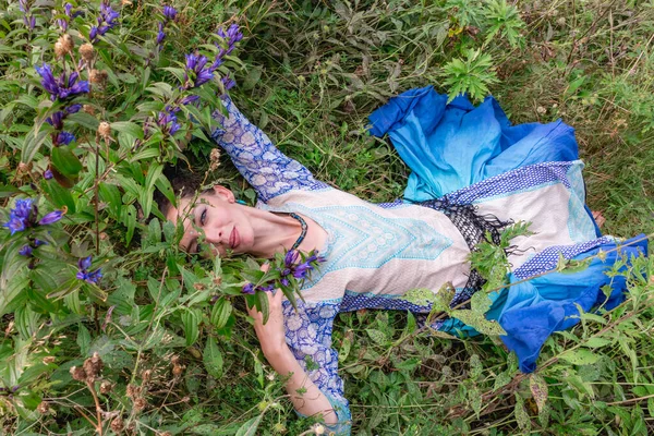 Bir kadın çiçek çayırında dinleniyor, Karpat dağlarında, yaz mevsiminde.