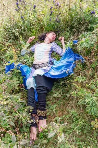 Bir kadın çiçek çayırında dinleniyor, Karpat dağlarında, yaz mevsiminde.