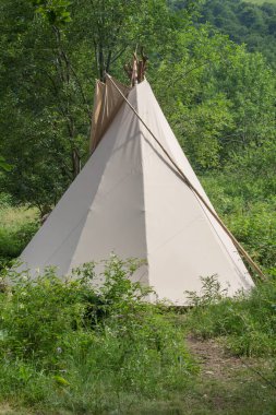 wigwam of beige color in a clearing in the Carpathian mountains, summer vacation, ethnic housing