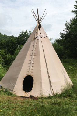 wigwam of beige color in a clearing in the Carpathian mountains, summer vacation, ethnic housing