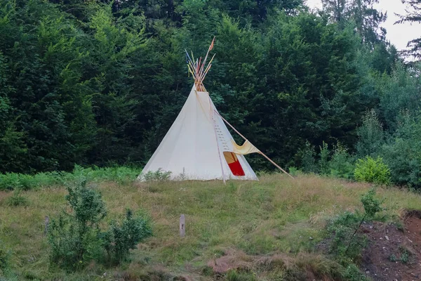 wigwam of beige color in a clearing in the Carpathian mountains, summer vacation, ethnic housing