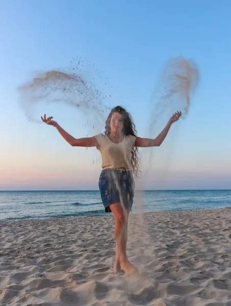 girl teenager plays sand on the Black Sea beach, summer vacatio