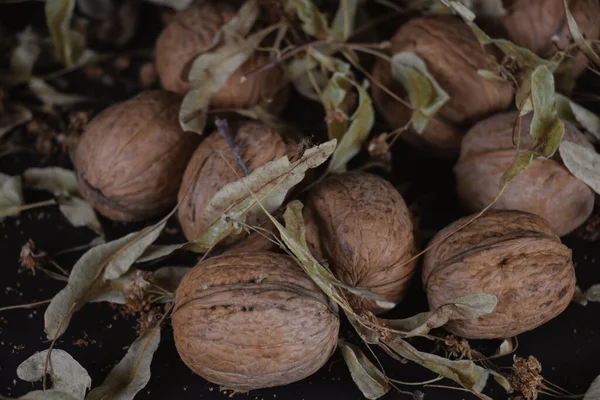 Walnut Green Yellow Leaves Background Close Chopped Nuts Lie Black — Stock Photo, Image