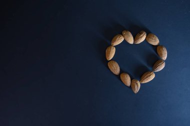 Mavi arka planda kalp şeklinde nefis badem fıstıkları, Sevgililer Günü için duvar kağıdı.