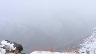 Kış rüzgarında dağ kanyonu, kar ve sis. 4k