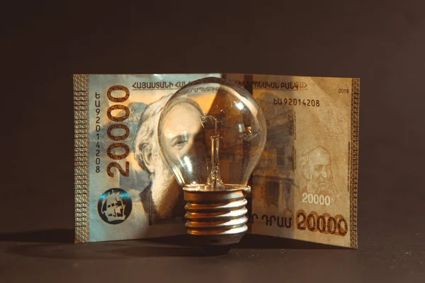 电灯泡和亚美尼亚德拉姆钞票的概念危机 背景为黑色 概念危机 世界经济 能源危机 — 图库照片