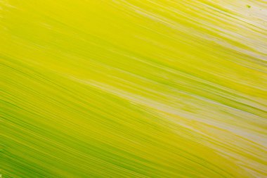 Kağıdın yüzeyinde yeşil ve sarı boya beyaz arka planda fırçayla boyanmış.