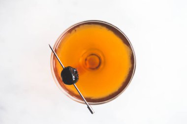 Manhattan kokteyli ve yukarıdan gelen kiraz garnitürü.