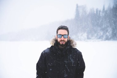 Young man isolated in nature during snowy winter day