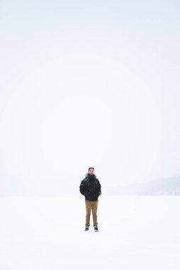 Young man isolated in nature during snowy winter day