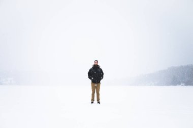 Young man isolated in nature during snowy winter day