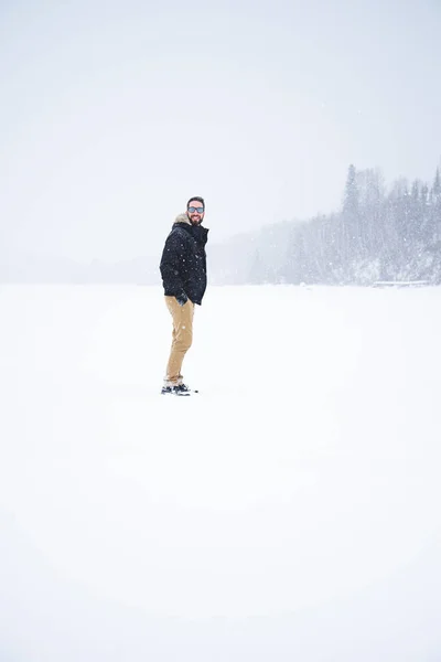 Young man isolated in nature during snowy winter day