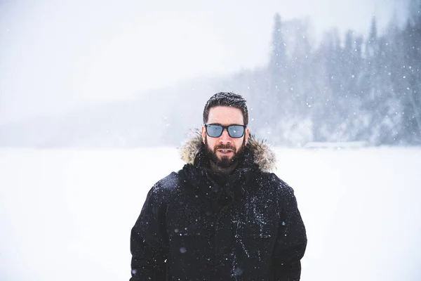 Young man isolated in nature during snowy winter day