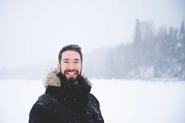 Young man isolated in nature during snowy winter day