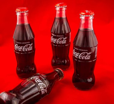 Almeria, İspanya; 25 Kasım 2021: Kırmızıda izole edilmiş kırmızı metal kapaklı 200 ml klasik Coca-Cola cam şişe kompozisyonu. Coca Cola Şirketi dünyanın en ünlü şekerli meşrubatlarından birini üretir.