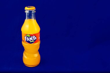 Almeria, İspanya; 25 Kasım 2021: 200ml Portakal aromalı Fanta şişesi, mavi üzerine metal kapaklı klasik cam şişe. Fanta, Coca-Cola Company 'nin bir ürünü olan karbonatlı meşrubat içeceğidir. Yatay olarak. Yazı.