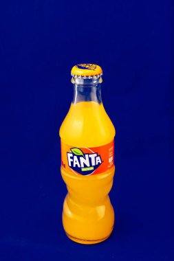 Almeria, İspanya; 25 Kasım 2021: 200ml Portakal aromalı Fanta şişesi, mavi üzerine metal kapaklı klasik cam şişe. Fanta, Coca-Cola Company 'nin bir ürünü olan karbonatlı meşrubat içeceğidir. Dikey. Yazı.