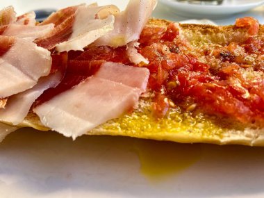 Kahvaltıda meşe palamudu ile beslenmiş jambon, siyah bacak rendelenmiş domates yağı ve tuzlu ve biberli ekmekle servis edilir. İber jambonu. Yakın plan.