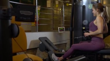 Kız formda salıncakta sallanıyor formda eğitim gücü, sağlıklı aktif insanlar kadın kardiyo, erkek insan. Spor giysileri atletik ileri bisiklet makinesi