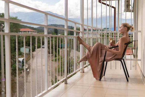 La ragazza si siede sul balcone delle montagne e il cielo blu sullo sfondo della bellezza bello adulto relax all'aperto al di fuori relax, viaggi estivi. resort rilassante, colazione in hotel — Foto Stock