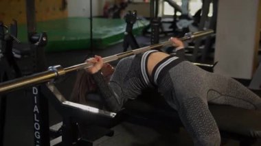 Fitness eksantrik konsantrasyon halteri, formda bir kızı kaldırma, ağırlık kaldırma. Sağlıklı profesyonel sporcu.