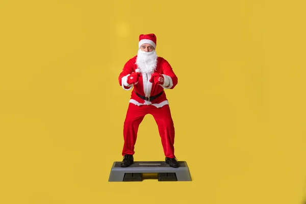 Santa Claus żółty styl żywności, szelki szybkie wakacje senior, zabawy brodaty wieczór świętować na kroku fitness platforma — Zdjęcie stockowe