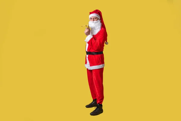 Święty Mikołaj żółty jeść szybko Boże Narodzenie człowiek zabawa stary. Modny czerwony dojrzałe, świętować zjada banana z jego prawej ręki — Zdjęcie stockowe