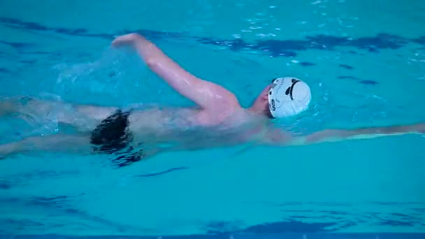 Nadador profesional en una piscina deportiva estilo de vida saludable concepto gorra de natación atleta deporte lentamente, En el agua de la tarde competitiva desde el entrenamiento de inicio de ejercicio, persona recreación. vueltas de natación — Vídeo de stock