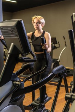 Spor kıyafetlerini giyip spor yaparken spor yaparken spor yapmak için spor yapan genç bir spor eğitmeni. Kardiyo döngüsü yaşam, fitness