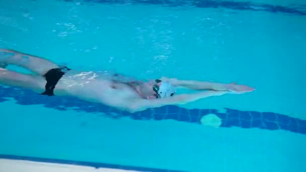 Nuotatore professionista in una piscina sportiva sano concetto di stile di vita cuffia galleggia lentamente attività, per spruzzi d'acqua per la resistenza e l'inizio muscolare, persona ricreativa. forte nuoto profondo, nuotare — Video Stock