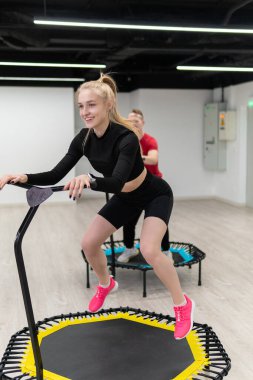 Trambolinde spor yapan kadın ve erkek grubu, fitness antrenmanı, sağlıklı bir hayat - trambolin grubu batut eğitmeni, sağlıklı bir konsept, kadın sporculardan genç hareketlere, gülümseyen