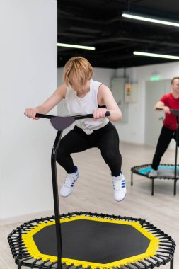 Trambolinde spor yapan kadın ve erkek grubu, fitness antrenmanı, sağlıklı bir hayat - trambolin grubu batat kızı konsepti, sağlıklı, genç görünümlü, formlu, güzel bir kadın atletizmi için
