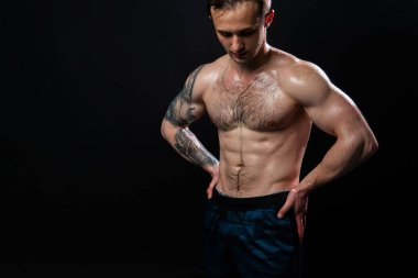 Siyah arka plandaki adam spor yaparken halterleri şişirmeye devam ediyor seksi sporcu kaslı sporcu kaslı atletik ağır, üstsüz genç güç, bir eli arkada, gergin güzel vücuda basın.