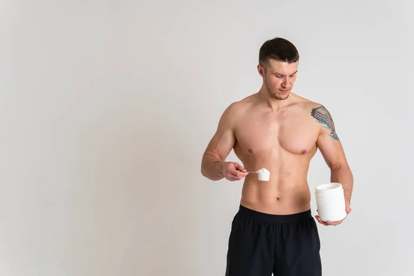 Fitness protein kavanozları beyaz arka planda vücut geliştirme tozu güçlü ağrı kesiciler genç ve hasta erkekler. Boyun tutması, daha az acı çekmesi.