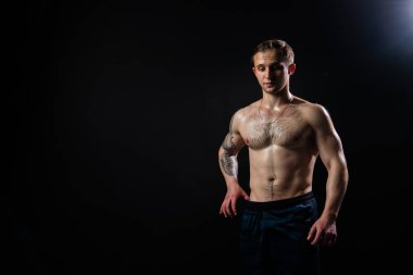 Siyah arka plandaki adam, vücut geliştirme halterlerinde ağırlık kaldırmada, ağırlık kaldırmada, ağırlık kaldırmada, ağırlık kaldırmada yükselmeye devam ediyor. Çekici bir yetişkin. Basına bak ve ölçü al.