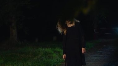 Korkunç kadın kameraya bakar, karanlıktan çıkar..