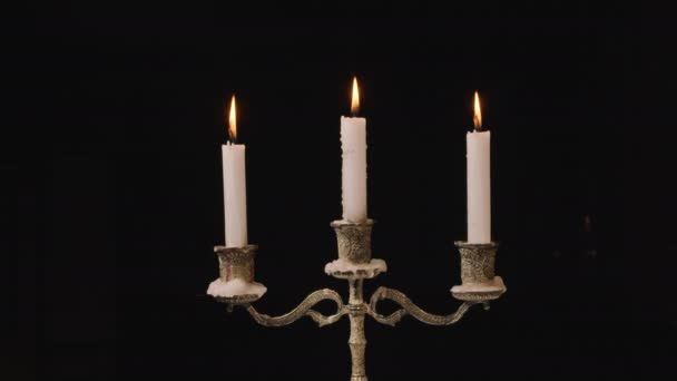 3 burning candles in a candlestick. Looping for use as a background or illustration for memories or celebrations. The wind extinguishes the flame Eternal flame. — Stock Video