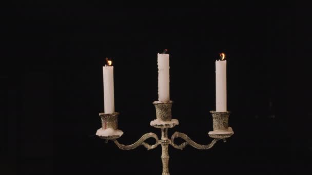 3 candele accese in un candelabro. Looping per l'uso come sfondo o illustrazione per ricordi o celebrazioni. Il vento spegne la fiamma Eterna fiamma. — Video Stock