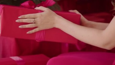 Kadınların elleri, otelin yılbaşı ağacının yanına kırmızı hediyeler koyar. Kadın, Noel tatiline hazırlanıyor..