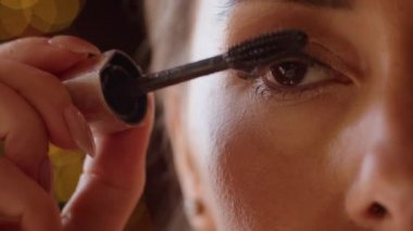 Yakın plan, bir kadın otelde kirpiklerini rimelle boyuyor, bir kadın Noel tatiline hazırlanıyor..