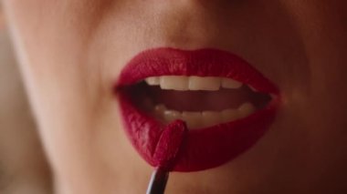Yakın plan, bir kadın dudaklarını kırmızı rujla boyuyor, bir kadın Noel tatiline hazırlanıyor..