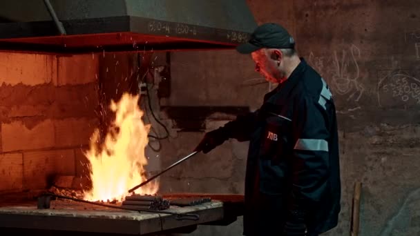 Krivoy Rog, Ουκρανία - 06.11.2021 ένας σιδεράς σε ένα σιδηρουργείο θερμαίνει μέταλλο σε ένα σιδηρουργείο, βαριά βιομηχανία. — Αρχείο Βίντεο