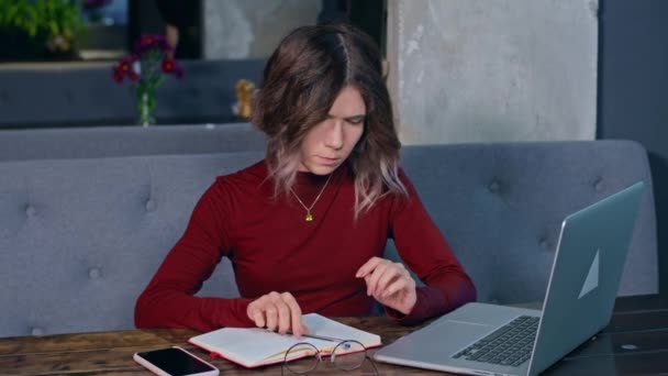 Mujer trabajando con el cuaderno en la mesa — Vídeos de Stock