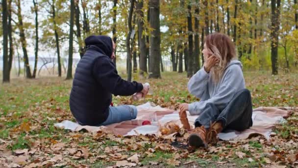 Ευτυχισμένο φθινοπωρινό ζευγάρι που διασκεδάζει την φθινοπωρινή σεζόν — Αρχείο Βίντεο