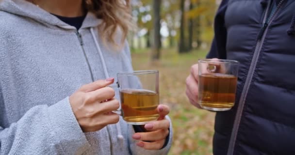 Gelukkig man en jonge vrouw drinken thee in het bos in de herfst, wandelen in het bos. — Stockvideo