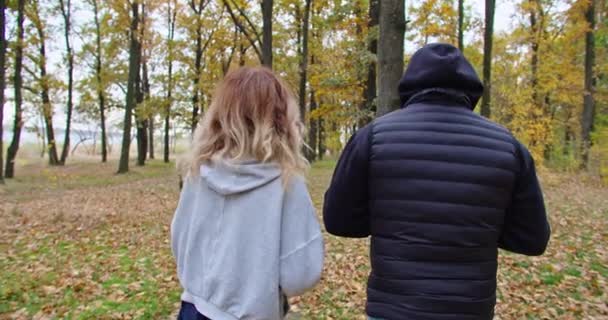 Heureux gars et jeune femme boire du thé dans la forêt en automne, marcher dans la forêt. — Video