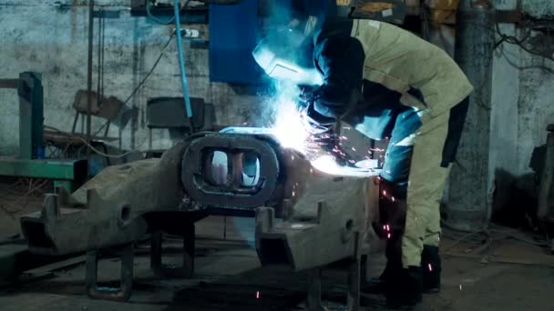 Industria pesada, soldador suelda piezas de metal para la reparación de automóviles — Vídeos de Stock