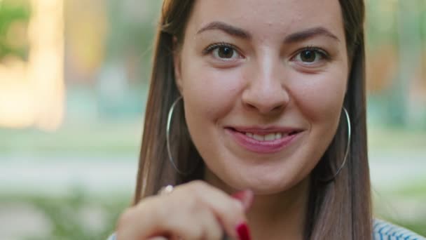 Relaxado sorrindo mulher satisfeita com xícara de café vermelho em pé na extremidade da rua desfrutando de um dia ensolarado — Vídeo de Stock